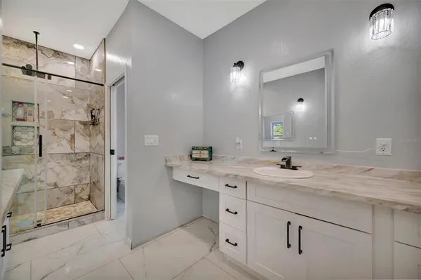 a spacious bathroom with a granite countertop sink mirror and shower