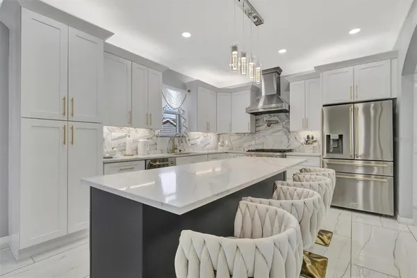 a kitchen with kitchen island a stove a refrigerator and a sink