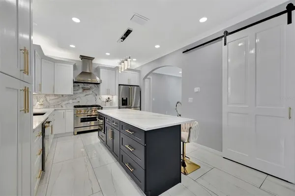 a kitchen with stainless steel appliances a sink stove and refrigerator