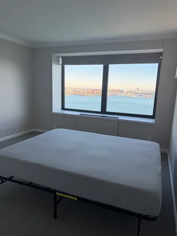 a bed sitting in a bedroom next to a window