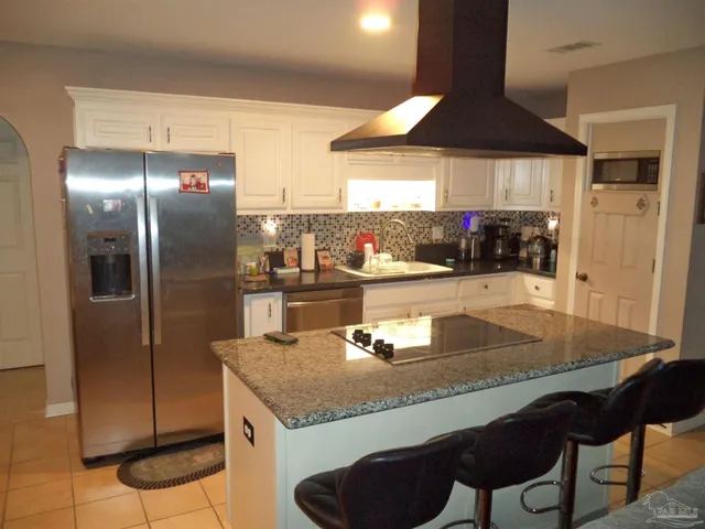 a kitchen with granite countertop a table and chairs