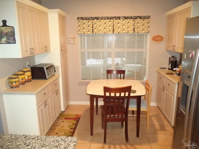 a kitchen with a table chairs sink and cabinets