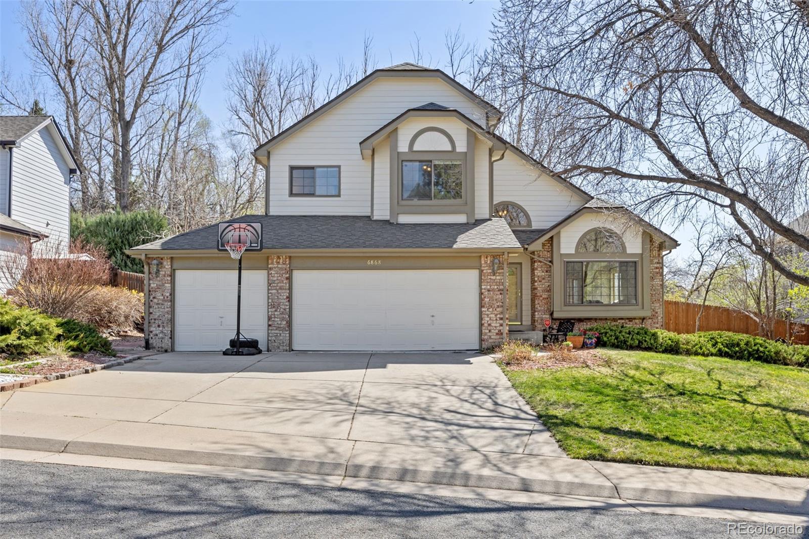 6868 Johnson Street Arvada, CO 80004 - Photo 1 of 39 a front view of a house with a yard and garage