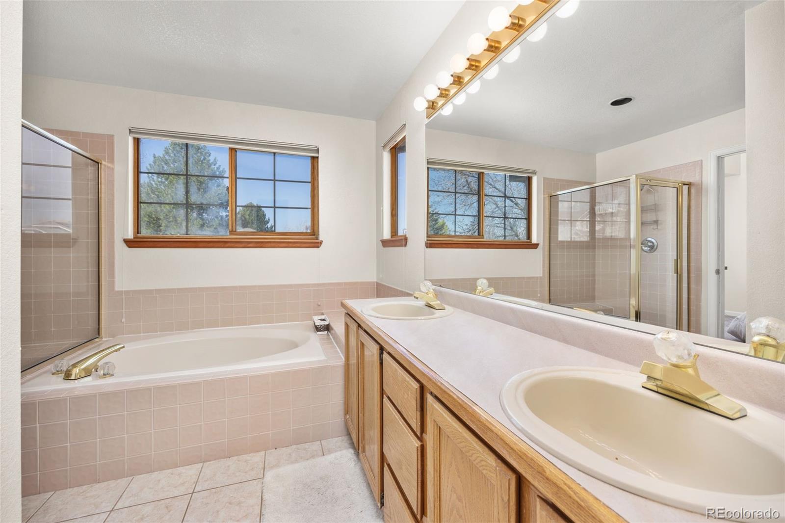 6868 Johnson Street Arvada, CO 80004 - Photo 16 of 39 a bathroom with a granite countertop tub sink and mirror