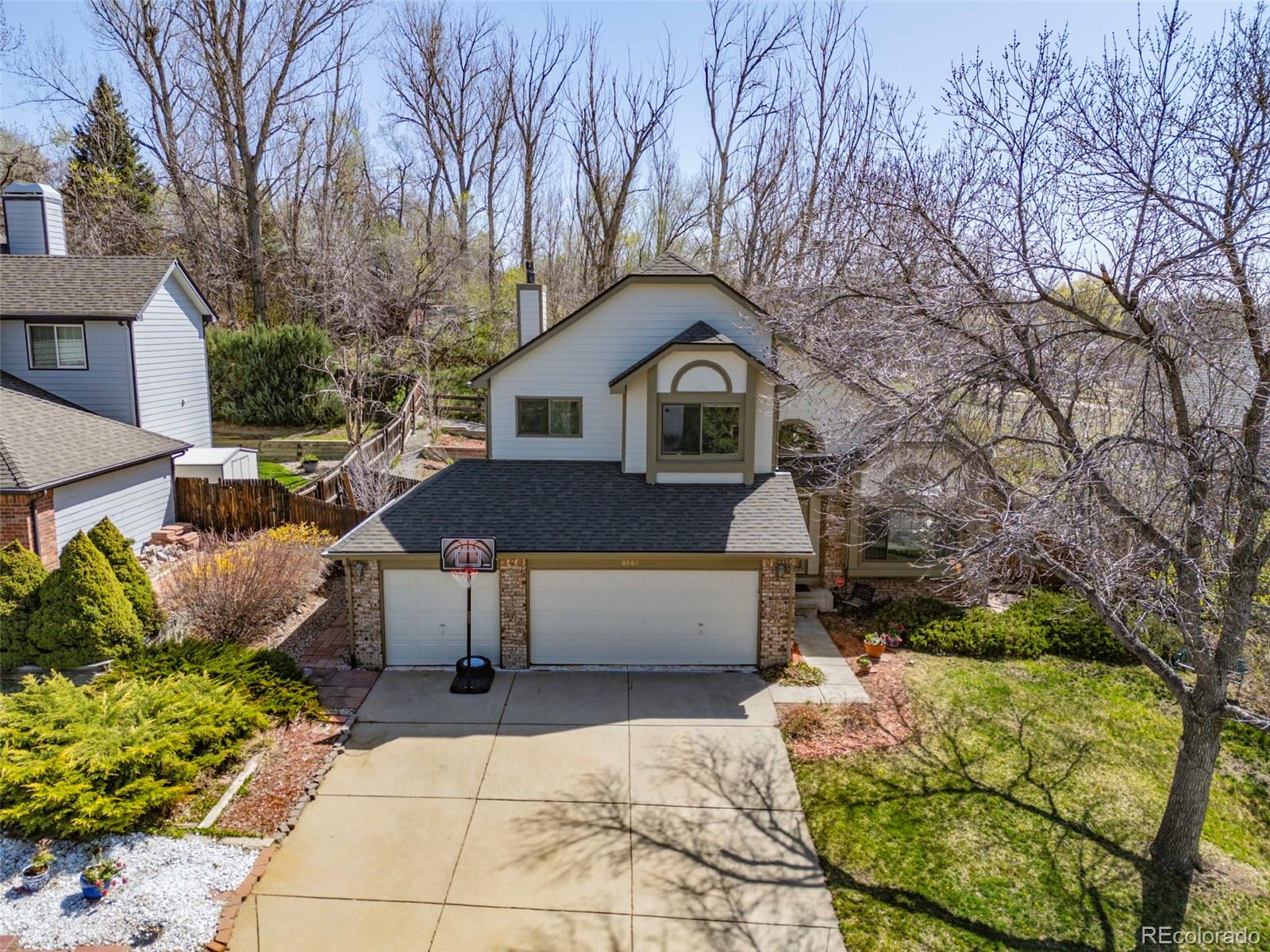 6868 Johnson Street Arvada, CO 80004 - Photo 2 of 39 a front view of a house with a garden