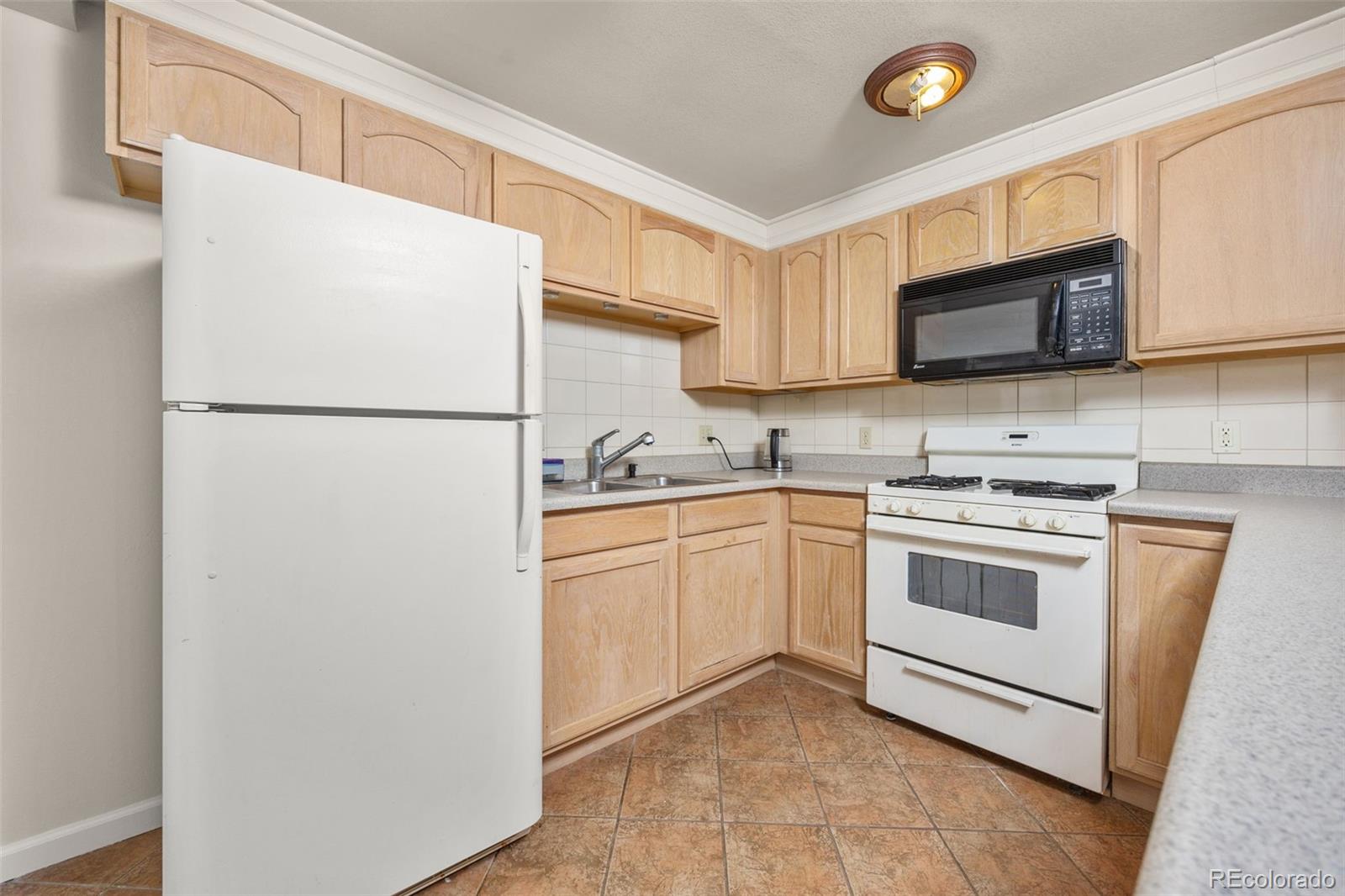6868 Johnson Street Arvada, CO 80004 - Photo 22 of 39 a white refrigerator freezer sitting in a kitchen