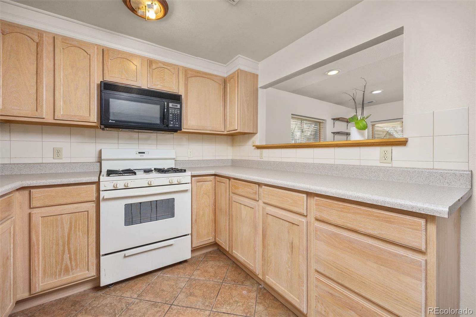 6868 Johnson Street Arvada, CO 80004 - Photo 23 of 39 a kitchen with white cabinets stainless steel appliances and sink