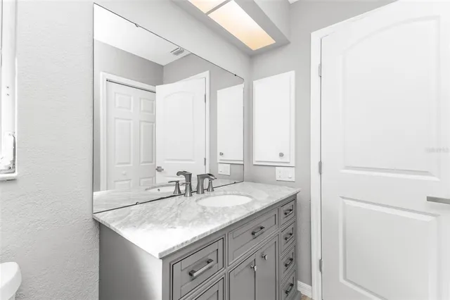 an empty room with wooden floor ceiling fan and windows