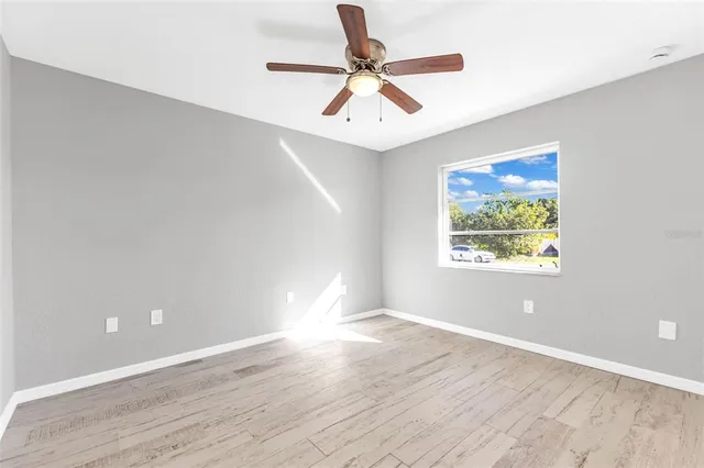 a view of empty room with wooden floor