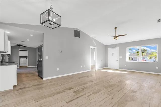 a view of a big room with wooden floor and windows