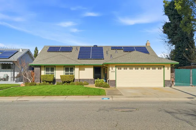 a front view of a house with a garden and plants
