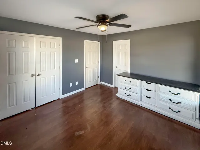a view of an empty room with window and cabinet