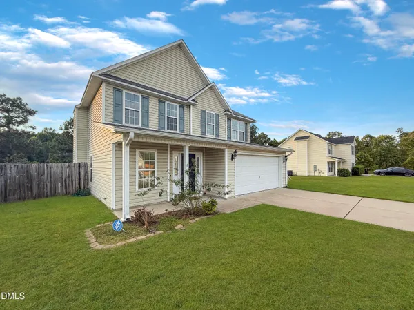 a front view of a house with a yard and garage