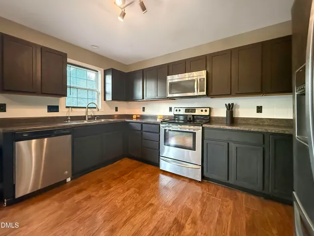 a kitchen with stainless steel appliances granite countertop a sink stove and microwave