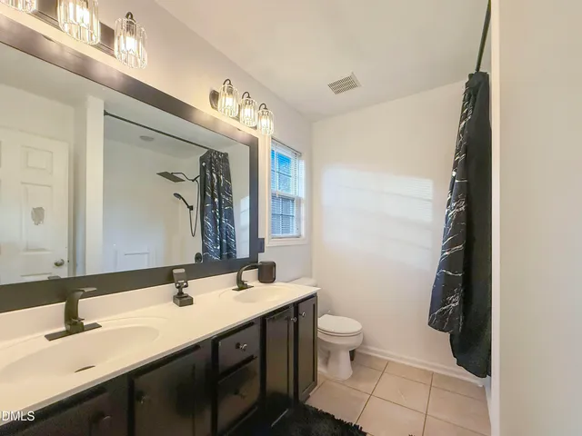 a bathroom with a double vanity sink and a mirror