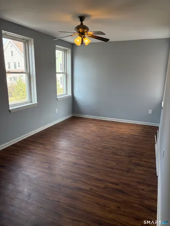 a view of an empty room with window and wooden floor