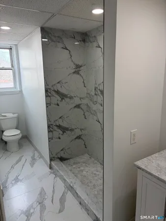 a bathroom with a granite countertop shower and a toilet