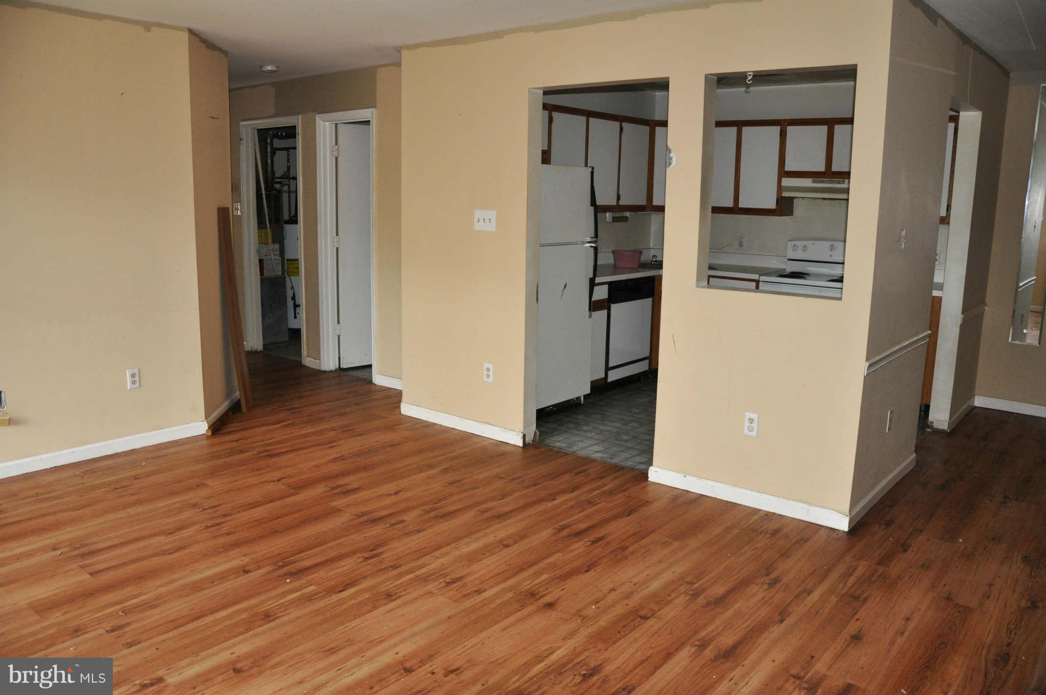 114 Timberlake Terrace, Unit 2 Stephens City, VA 22655 - Photo 4 of 22 an empty room with wooden floor and way to kitchen