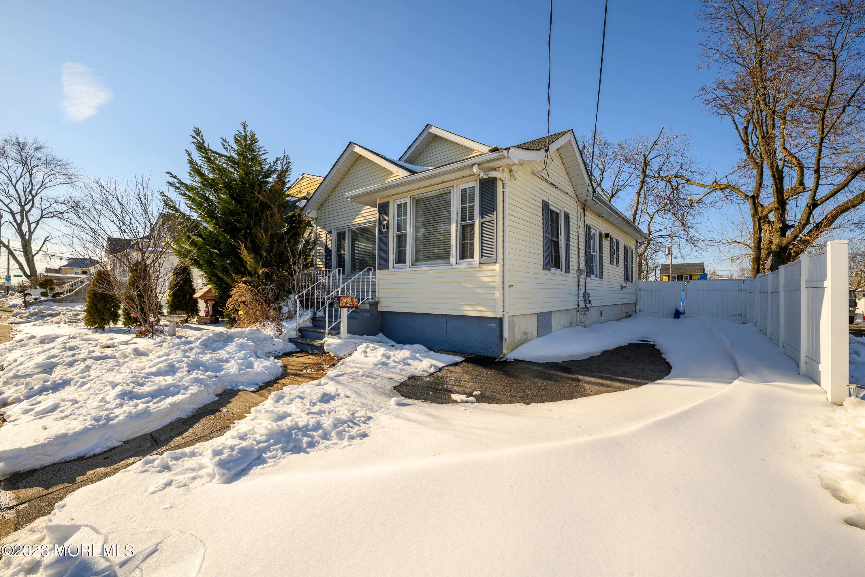 a view of a white house with a yard covered in snow