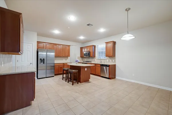 a kitchen with stainless steel appliances granite countertop a sink stove and refrigerator