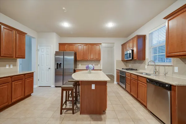 a kitchen with stainless steel appliances granite countertop a refrigerator and cabinets