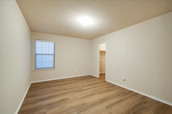 a view of empty room with wooden floor