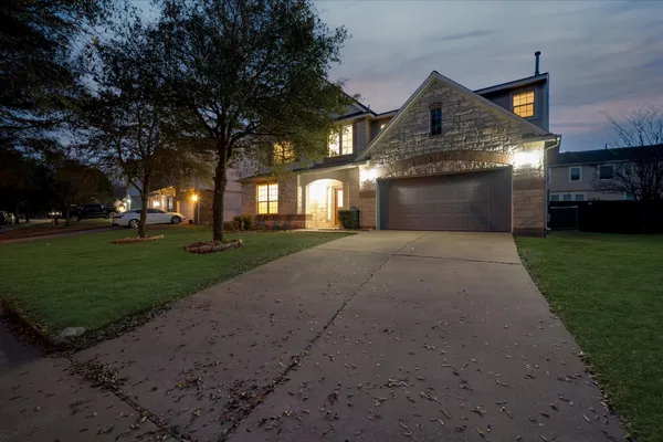 a front view of a house with a yard and trees