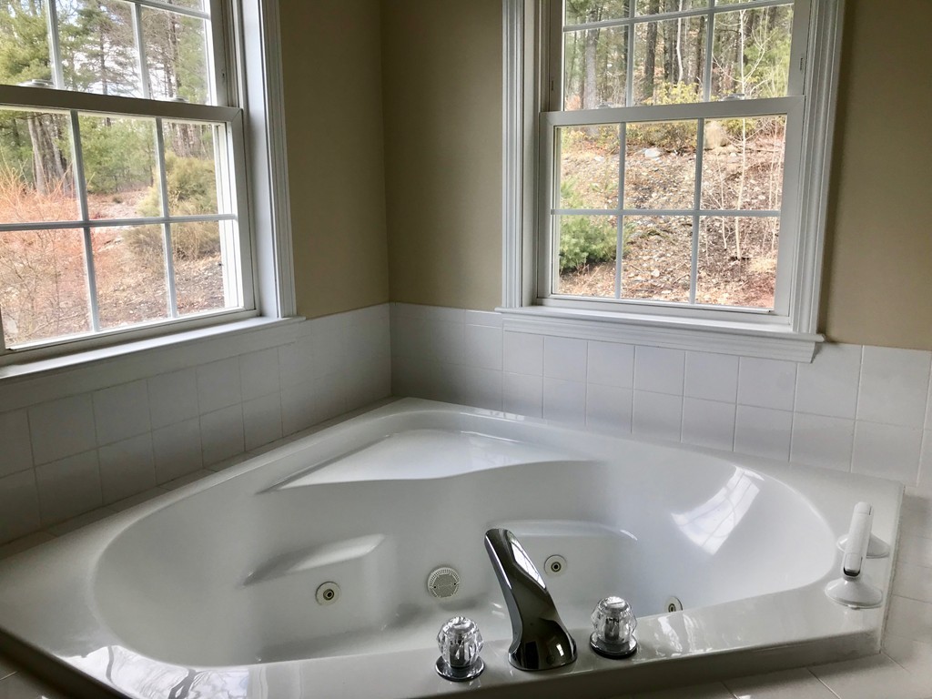 408 Nicholas Drive Lancaster, MA 01523 - Photo 22 of 30 a bath tub sitting in a bathroom next to a window