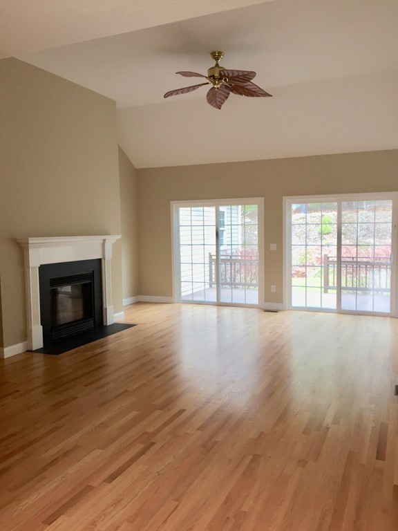 408 Nicholas Drive Lancaster, MA 01523 - Photo 5 of 30 a view of an empty room with wooden floor and a fireplace