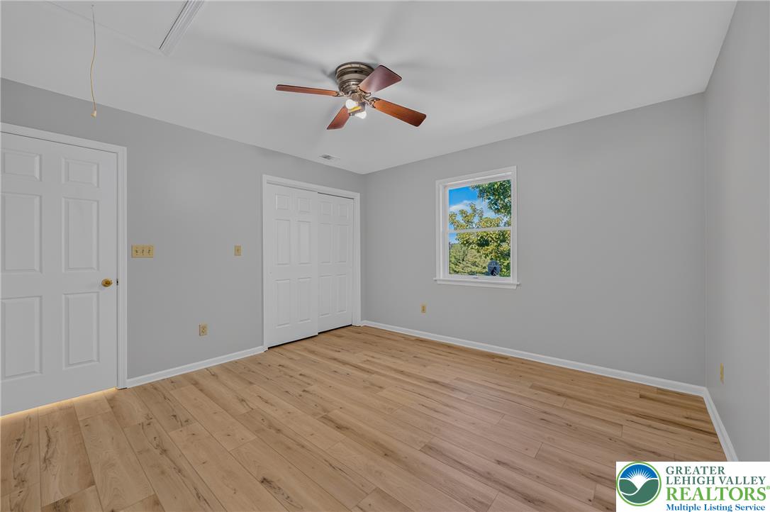 630 Clearfield Road Nazareth, PA 18064 - Photo 61 of 100 Gleaming hardwood floors and a wide window create an inviting secondary bedroom retreat.