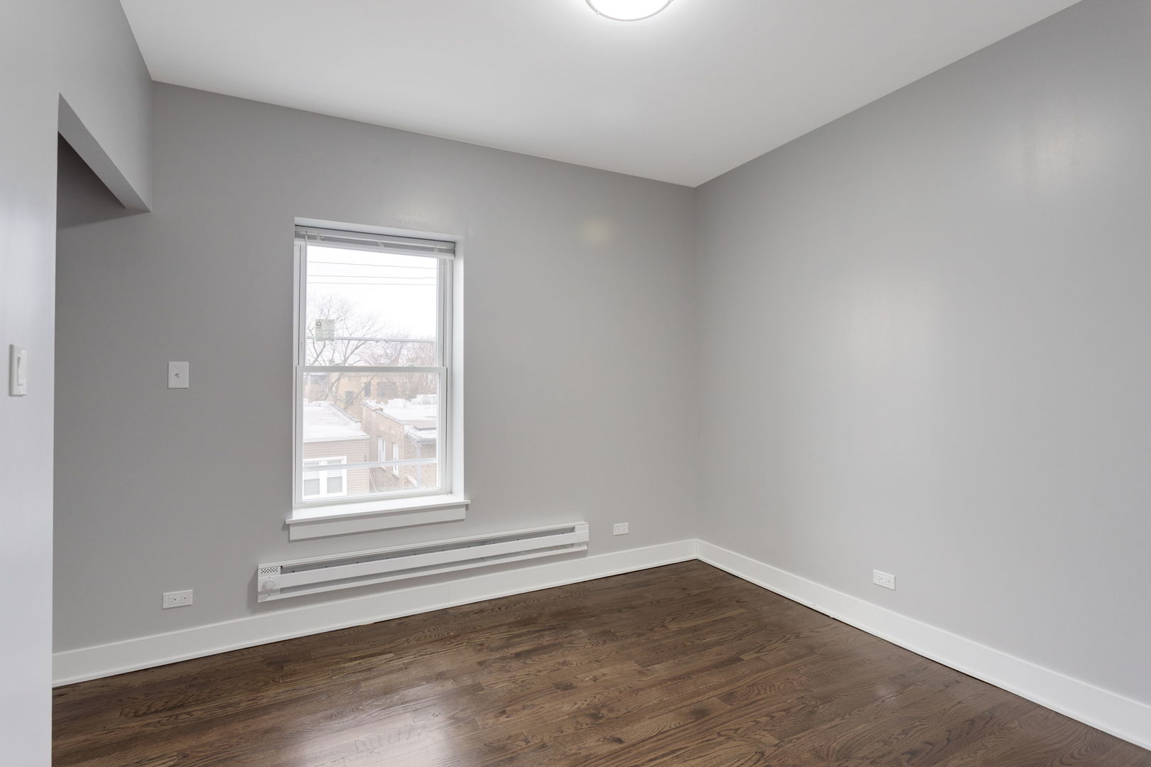 8022 South Ellis Avenue, Unit 1B Chicago, IL 60619 - Photo 6 of 8 an empty room with wooden floor and windows