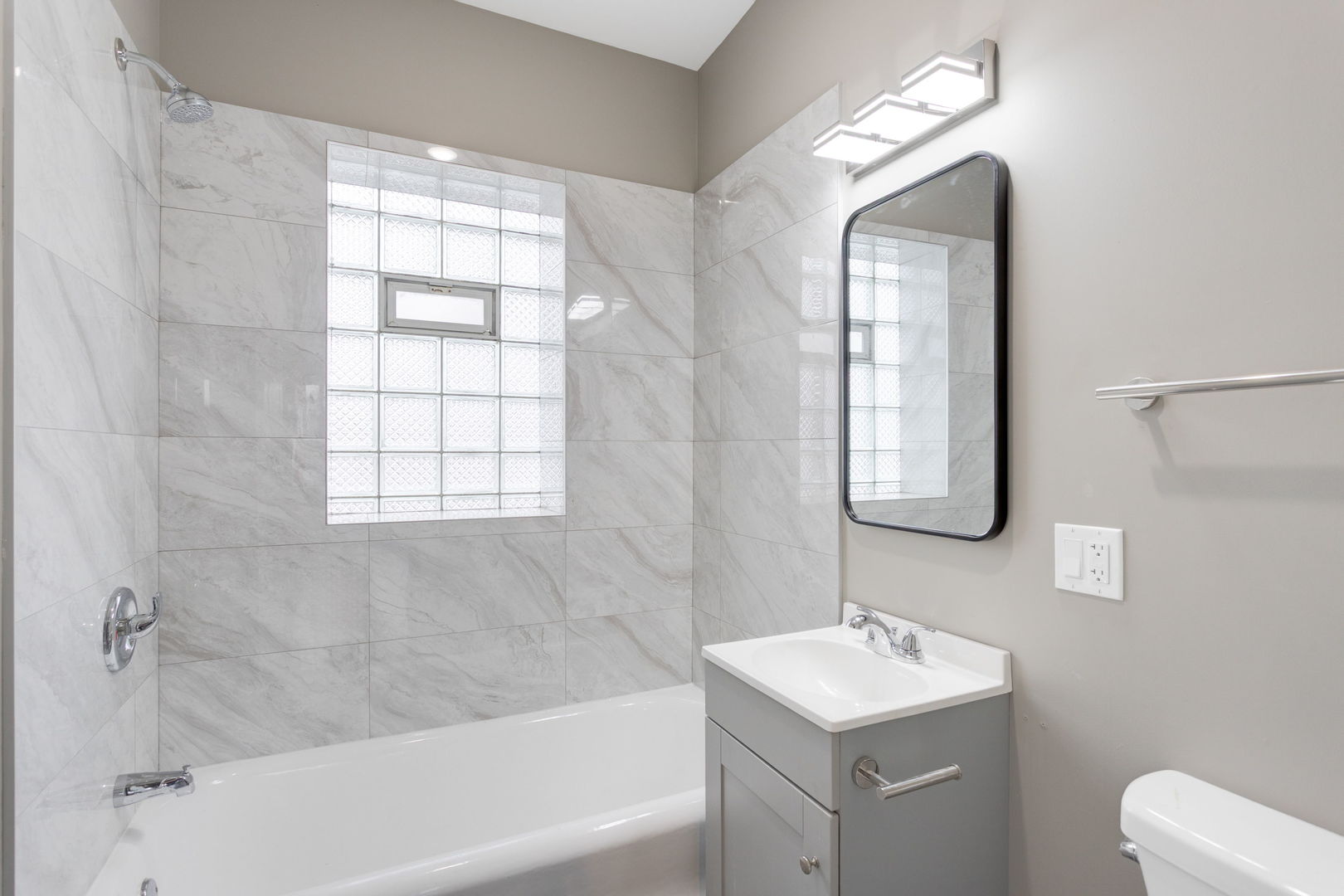 8022 South Ellis Avenue, Unit 1B Chicago, IL 60619 - Photo 8 of 8 a bathroom with a sink toilet vanity and bathtub
