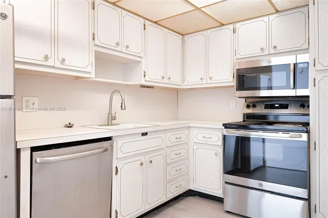 a kitchen with white cabinets and white appliances