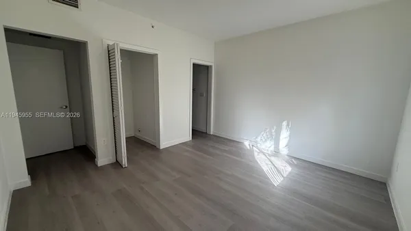an empty room with wooden floor and closet