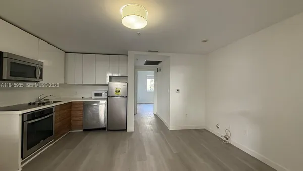 a kitchen with sink a microwave and cabinets