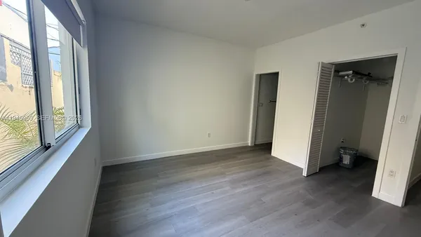 a view of a room with wooden floor and a window