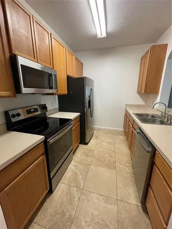 a kitchen that has a sink stainless steel appliances a counter space and cabinets