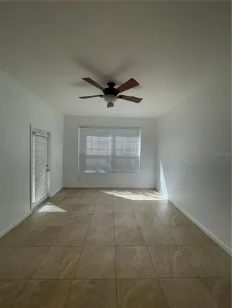 a view of an empty room and a ceiling fan
