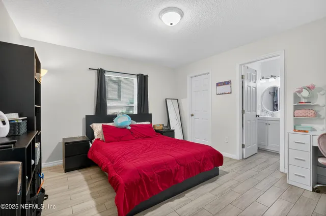 a spacious bedroom with a bed and a flat screen tv