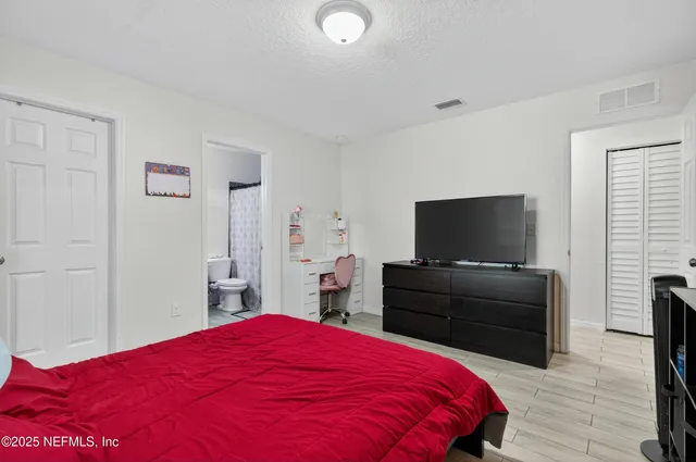 a bedroom with a bed and a flat screen tv