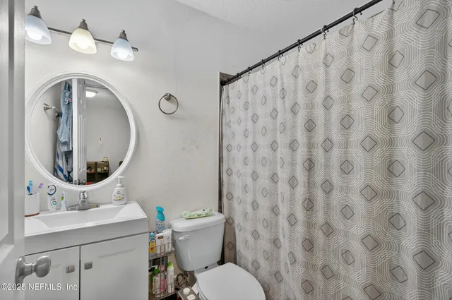 a bathroom with a toilet a sink and a mirror