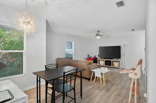 a living room with furniture a flat screen tv and a large window