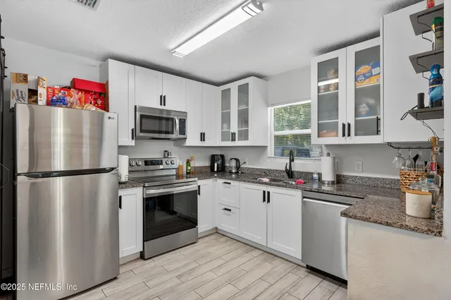a kitchen with stainless steel appliances a refrigerator sink and microwave