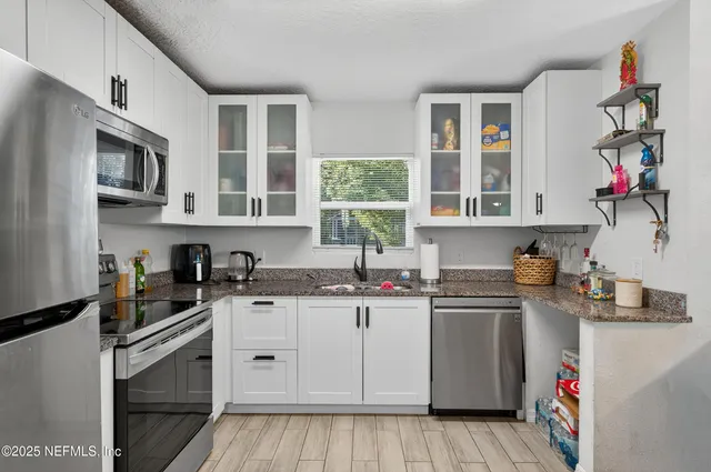 a kitchen with stainless steel appliances granite countertop a sink and cabinets