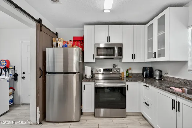 a kitchen with a refrigerator stove and microwave