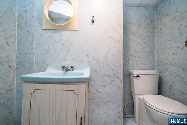 a bathroom with a granite countertop toilet sink and mirror