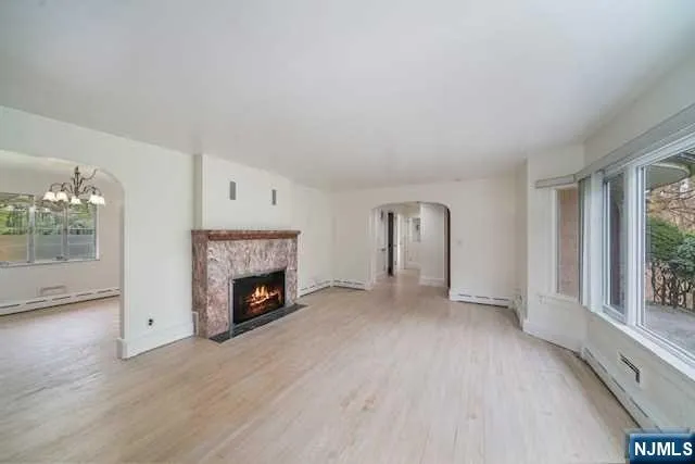 an empty room with windows and fireplace