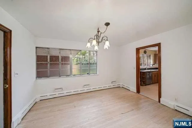 an empty room with windows and chandelier