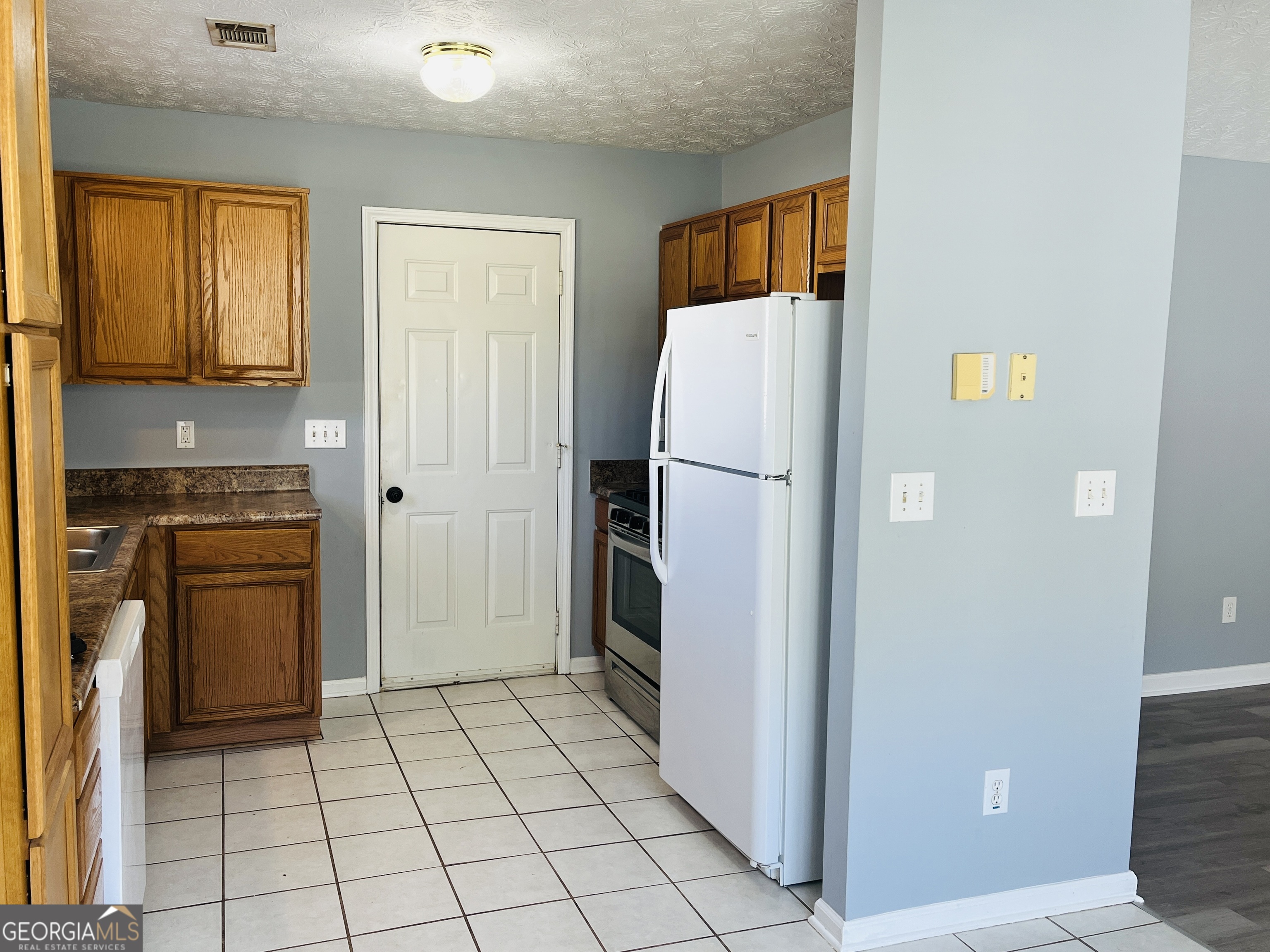 405 Peeks Crossing Drive Senoia, GA 30276 - Photo 6 of 31 a kitchen with a refrigerator and cabinets