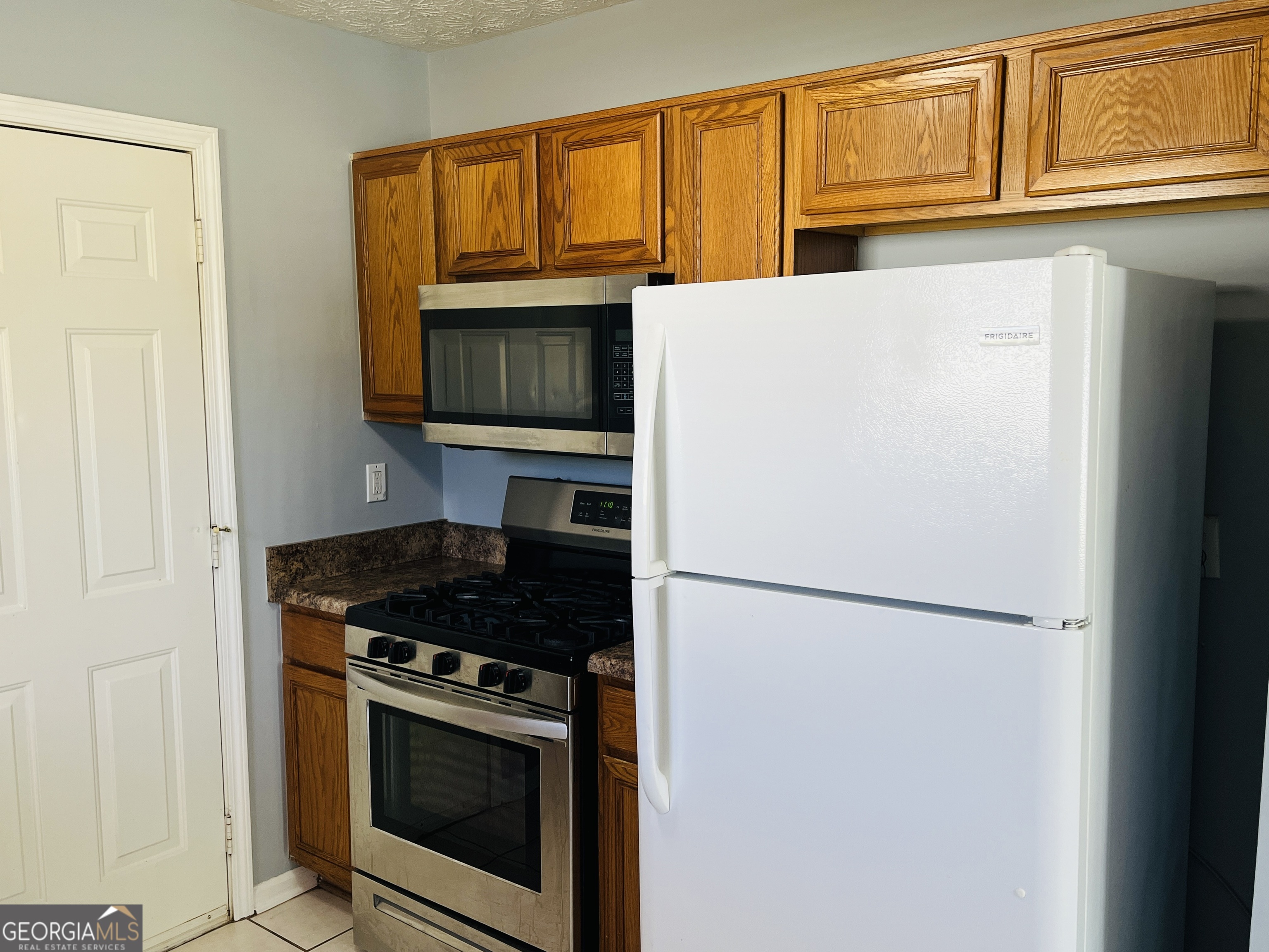 405 Peeks Crossing Drive Senoia, GA 30276 - Photo 8 of 31 a kitchen with stainless steel appliances granite countertop a refrigerator a stove a sink dishwasher and cabinets with wooden floor